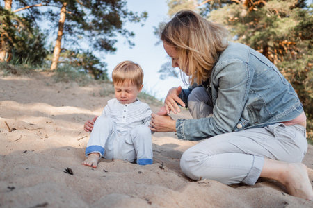 Cute Caucasian boy and happy mother together at coast. Pine prees on background. Image with selective focusの写真素材