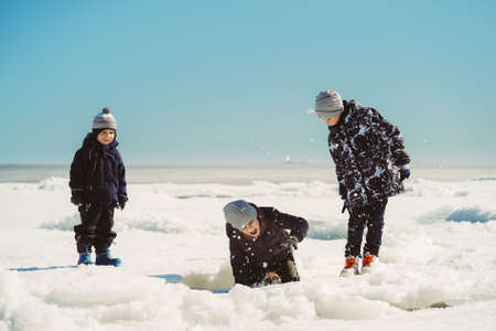 children walking on ice peeling of finland gulf. boy slump under ice cake. image with selective focus.の写真素材