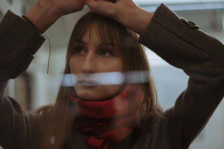 young woman lean on glass door of metro carriage. Loneliness and depression concept. Image with selective focusの写真素材