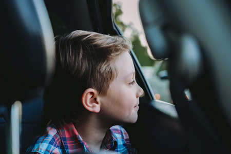 Handsome caucasian boy enjoy traveling by car sitting in child seat Recreation concept. Image with selective focusの写真素材