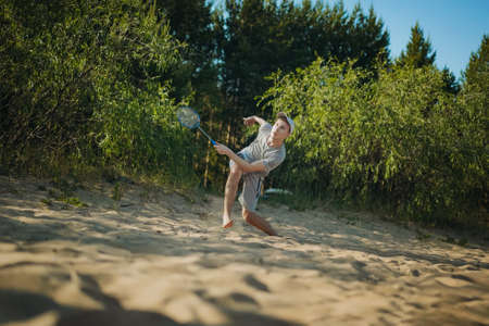 teenager boy playing badminton on the beach. Image with selective focus. high quality photoの写真素材