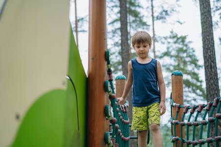 cute little boy having fun at the playground. Summer vacation in nature.の写真素材