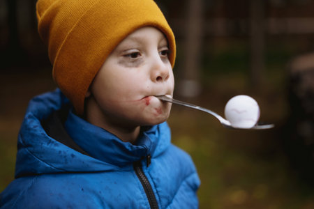 halloween games for kids. boy carry  pong eyeball holding spoon in mouth. Funny activities for childrenの写真素材