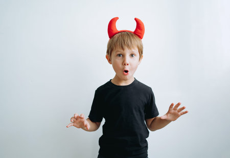 Halloween concept. cute little boy with red devil horns isolated on white background.の写真素材