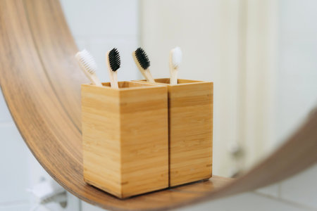 two toothbrushes in bamboo holder reflecting in bathroom mirror. Eco friendly conceptの写真素材