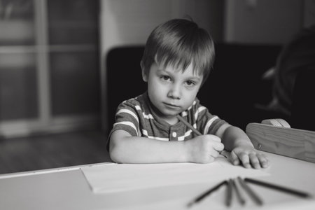 Adorable little toddler boy passionately drawing with color pencils. Image with selective focus . high quality photoの写真素材