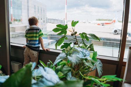 caucasian boy in airport watching waiting for plane. Travel conceptの写真素材