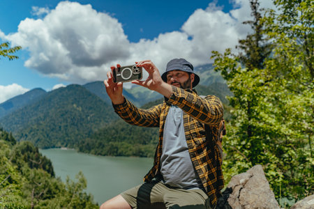 Hiking traveler handsome caucasian bearded man with backpack taking selfie against view of Lake Ritsa in Abkhaziaの写真素材