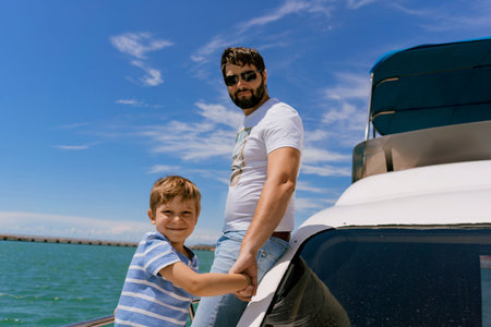 father and son sailing on yacht enjoying sea viewの写真素材