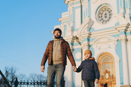 Young father walking with little son from orthodox cathedral holding child by hand. Image with selective focusの写真素材