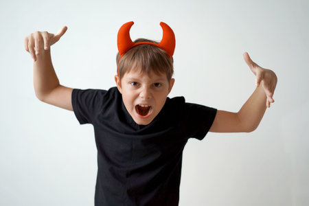 Halloween concept. cute little boy with red devil horns and pumpkin isolated on white background.