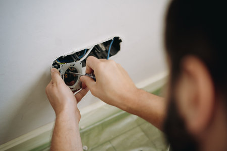 man installing socket. electrician hands holding screwdriver. Renovation, repair concept. Image with selective focusの写真素材