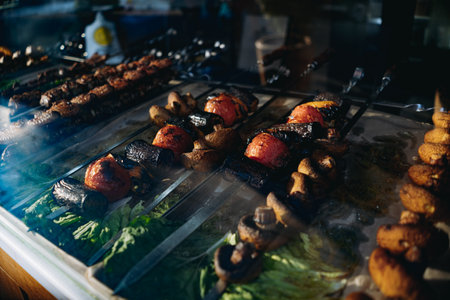traditional caucasian shish kebab at street food market. grilled champignons, tomatoes and other vegetablesの写真素材