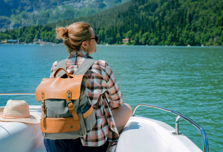 Hiking traveler woman with backpack enjoying beautiful view of turquois blue Lake Ritsa and...