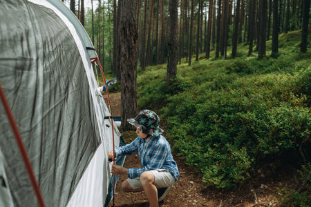 cute little caucasian boy putting up a tent. Family camping conceptの写真素材