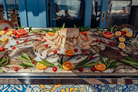 sea food on outside store counter. Fish and crab on ice decorated with fresh citrus fuitの写真素材