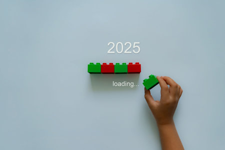Loading new year 2024 to 2025 with child hand putting green plastic block in progress bar. Start new...