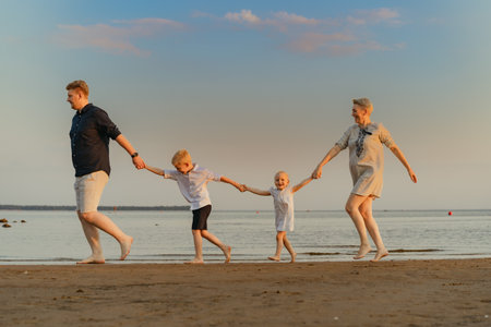 nice family having fun running in sea on sunset. Summer vacation with kids. High quality photoの写真素材