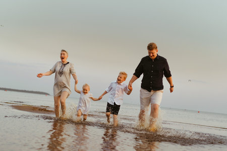 nice caucasian family having fun running in sea on sunset.Summer vacation with kids. High quality photoの写真素材