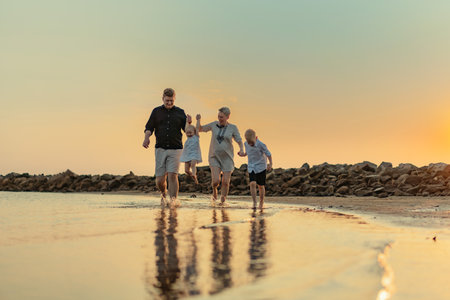 nice caucasian family having fun running in sea on sunset.Summer vacation with kids. High quality photoの写真素材