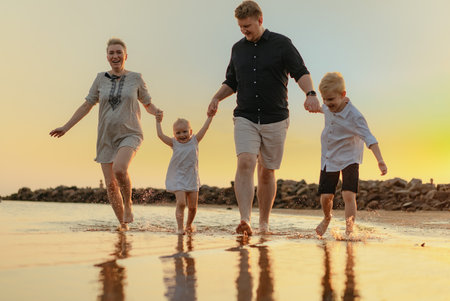 nice caucasian family having fun running in sea on sunset.Summer vacation with kids. High quality photoの写真素材