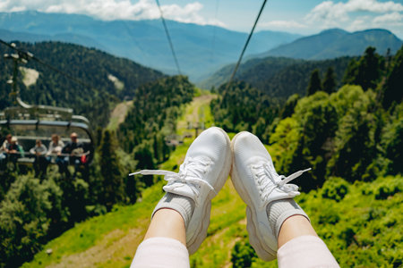 woman feet in sneakers in front of mountain view. cable road. High quality photoの写真素材