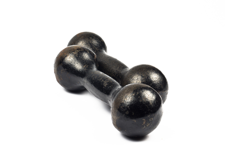 Two old cast iron black dumbbells on white backgroundの写真素材