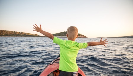 Brothers on a new adventure with father on a kayaking trip to a near by island to sleep under the stars. Concept photo of a family quality time, father and sons bond.の写真素材