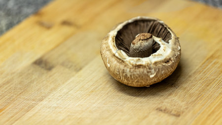 Brown champignon mushroom on a wooden board. Close up.の写真素材