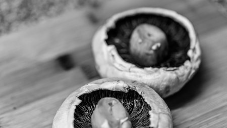 Fresh champignon mushrooms on a wooden table. Black and white photo.の写真素材