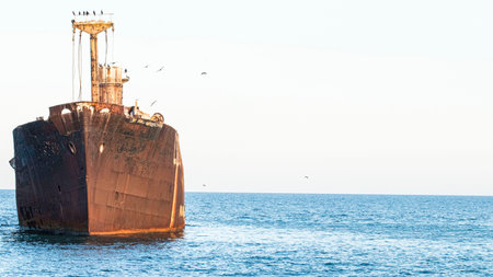 Old rusty ship wreck in the sea on a background of blue sky