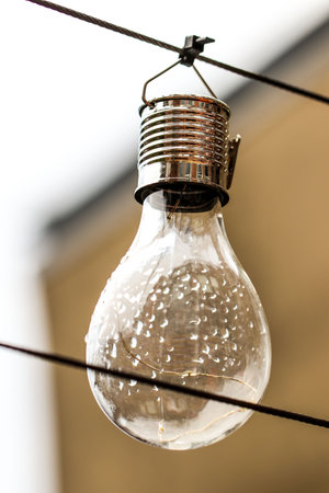 Close up of a lightbulb hanging on a wire with a blurred backgroundのeditorial素材