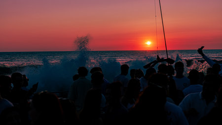 Silhouettes of people on the background of the sea at sunsetの写真素材