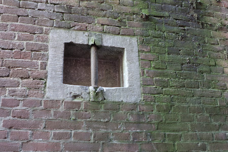 Broken window on the wall of an old brick house in the Netherlands