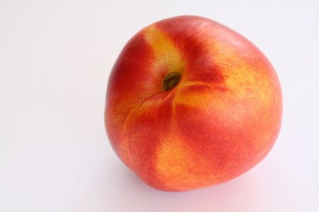 One fresh and juicy nectarine on white backgroundの写真素材
