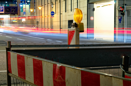 Construction site lamp at night with flowing traffic in the backgroundの写真素材