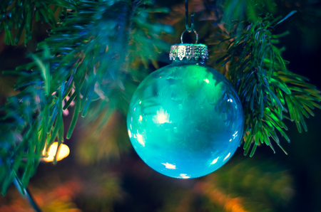 Christmas bauble on a Christmas tree and glowing lightsの写真素材