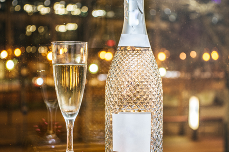 Champagne glass with fine champagne in front of the lights of a big cityの写真素材