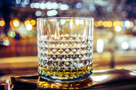 Whiskey glass with whiskey with bright lights at nightの写真素材