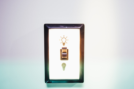 Antique light switch with a light bulb and lightingの写真素材