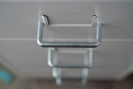 Drawer of a metal cupboard in white with metal gripsの写真素材