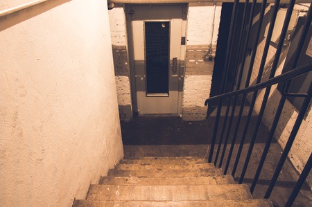 Cellar with a padlock and a cellar door in a tenement with a light switch in violet opticsの写真素材