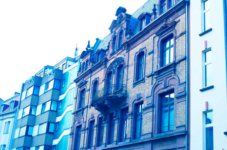 Old brick house surrounded by modern houses in a blue look