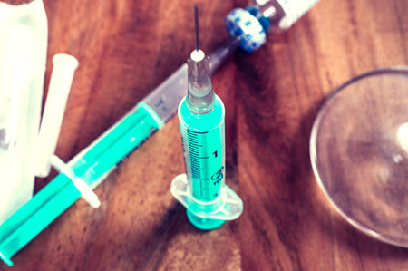 Syringe with cannula on a wooden table with medicine