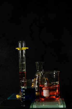 Scientific glassware with multi-colored liquids and a grunge filter applied.の写真素材