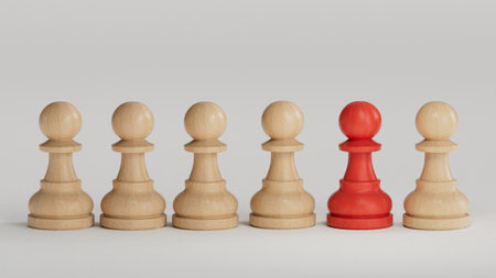 Wooden chess pieces with one red pawn standing out from the crowdの写真素材