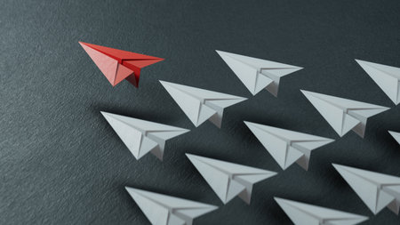 Leadership concept with red paper plane leading among white ones on black background