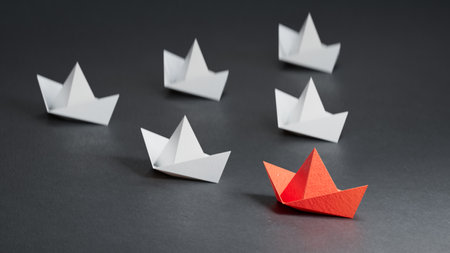 Leaderboat of Red paper ship concept between white paper ship. Key man and Business successful with one direction together. Black texture illustration background 3D.の写真素材