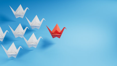 Row of paper swans. Business concept of creative innovation and leader swan. Flat lay red origami leader swan ahead of group white swans. Corporate strategy and successful solution.の写真素材
