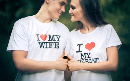 Young husband and wife with the words on the T-shirt I love my wife, I love my husbandの写真素材